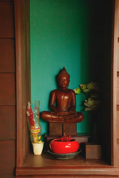 伝統的な仏壇の中に蓮の瞑想の位置に木製の仏像の垂直ショット — ストック写真