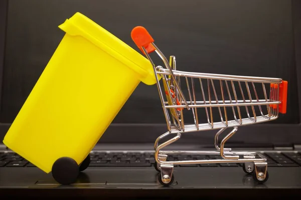 小型黄色のビン電子廃棄物処理を表すラップトップ上のショッピングカート — ストック写真