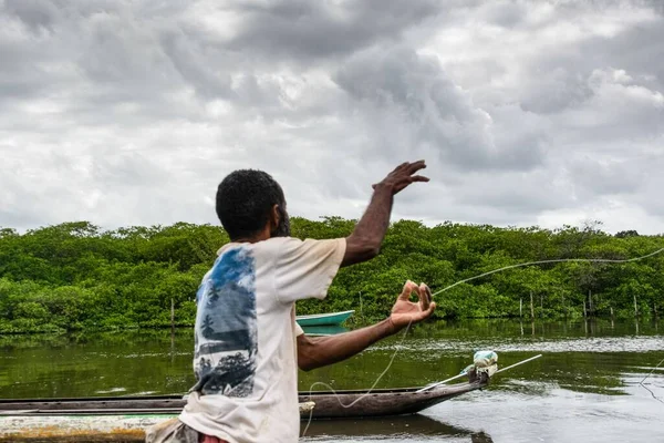 バイーア州アラトゥイプ市のジャガーリップ川の端で魚を捕まえるために餌を投げる漁師 — ストック写真