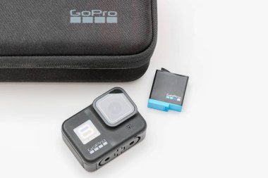 Üretici firma Gopro 'dan beyaz arka planda bataryası ve çantası olan bir aksiyon kamerası.