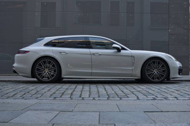 Porsche Panamera beyazı, şehir merkezine park ediyor.