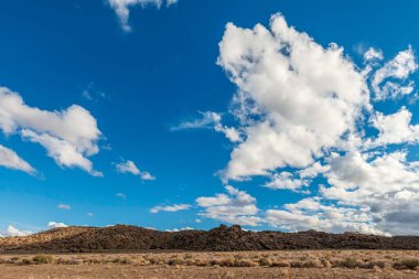 Nevada 'daki çöl dağlarının üzerindeki bulutların manzarası. Ufukta mavi gökyüzü.