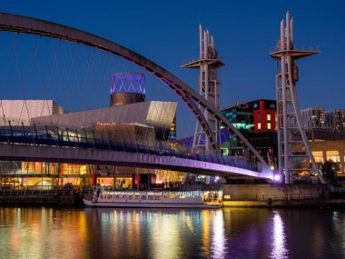 Salford Quays Manchester UK 2022 Salford Quays gece görüşü eğlence teknesiyle Lowery tiyatrosunun yanındaki köprünün altındaki nehirde