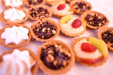 Beyaz masada farklı tatlara sahip kapkekleri yakından çek.