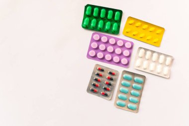 Çeşitli tıbbi ekipmanlar, termometre, ampuller, boru, uyuşturucu, tabletler, kapsüller, sprey, yama, şırınga, beyaz arka planda şişeler. İlaç.,