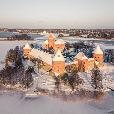 Ortaçağ Trakai Adası Kalesi 'nin donmuş gölle çevrili karlı bir kış gününde çekilmiş bir fotoğrafı.