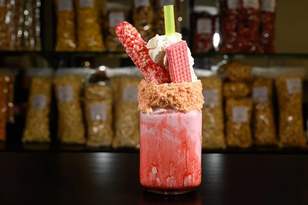 stock image A shallow focus shot of strawberry ice-cream in a jar with waffles, candy and straw