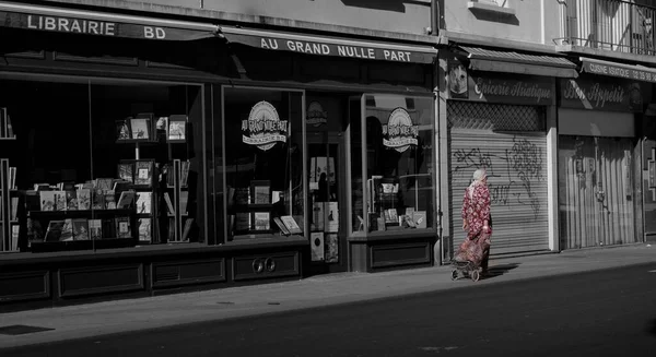 在法国的鲁昂 一个穿着红色衣服 背景是灰比例建筑的女人的一种精选颜色 — 图库照片