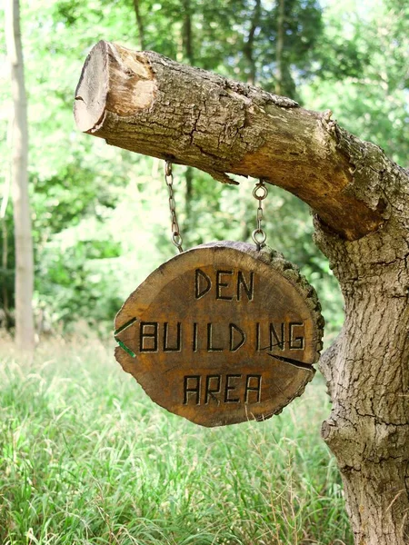 A vertical shot of a wooden sign with the text \