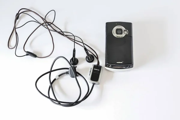 Vintage Nokia N70 Gsmumts Telefon Przewodowymi Słuchawkami Białej Powierzchni — Zdjęcie stockowe