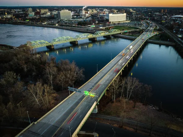 ニュージャージー州を背景に日の出とトレントンの街並みで川にかかる橋のドローンショット — ストック写真