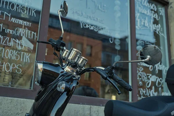 店の窓の前に停まっていた黒いスクーター — ストック写真
