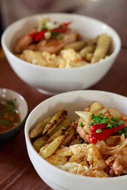 Bir kase dolusu ev yapımı kızarmış tavuk göğsü, yavru mısır ve yüksek proteinli keto kahvaltısı için çırpılmış yumurta.