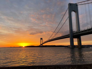 A scenic shot of the Verrazzano-Narrows Bridge between New York and Staten Island in USA during sunset clipart
