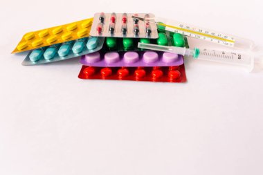 Çeşitli tıbbi ekipmanlar, termometre, ampuller, boru, uyuşturucu, tabletler, kapsüller, sprey, yama, şırınga, beyaz arka planda şişeler. İlaç.,