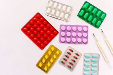 Çeşitli tıbbi ekipmanlar, termometre, ampuller, boru, uyuşturucu, tabletler, kapsüller, sprey, yama, şırınga, beyaz arka planda şişeler. İlaç.,