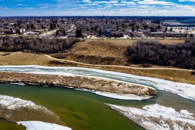 Donmuş Güney Saskatchewan Nehri 'nin mavi gökyüzünün altında bir kasabanın havadan çekilmiş görüntüsü.