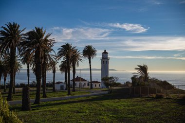 Gün batımında sahilde bir deniz feneri
