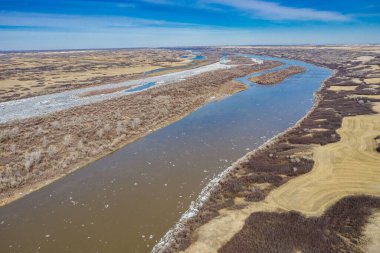 Geniş bir arazinin ve mavi gökyüzünün altındaki Güney Saskatchewan Nehri 'nin hava görüntüsü.