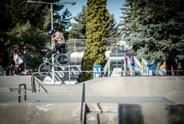 Kosice 'deki kaykay parkında BMX yarışında bisiklete atlayan genç bir adam.