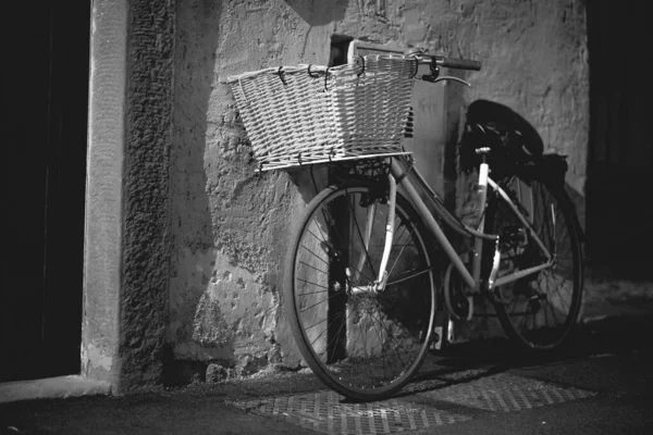 一辆自行车靠在墙上的灰度镜头 — 图库照片