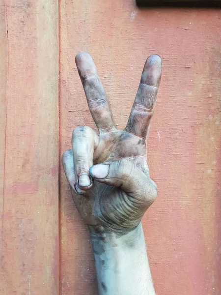 Eine Vertikale Aufnahme Eines Friedenszeichens Mit Schmutziger Hand Auf Rosa — Stockfoto