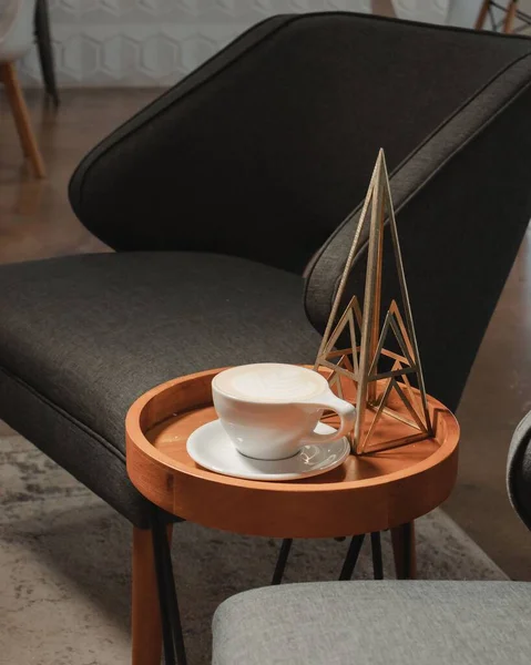 カプチーノと三角形の装飾が施された椅子とコーヒーテーブルの垂直 — ストック写真