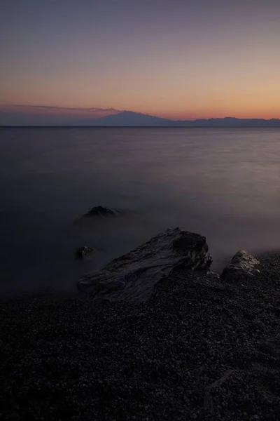 黄昏时分 在湖滨上的一块岩石 长期暴露在湖面上 — 图库照片