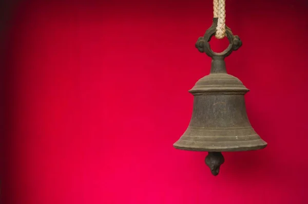 赤い背景に古い素朴な鐘 — ストック写真