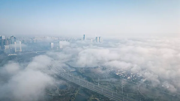 在多雾的天气下 在蓝天的坡度下俯瞰一座现代城市的鸟瞰图 — 图库照片