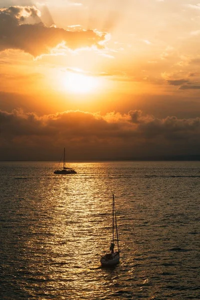 Malowniczy Widok Pionowy Łodzi Spokojnym Morzu Podczas Hipnotyzującego Zachodu Słońca — Zdjęcie stockowe
