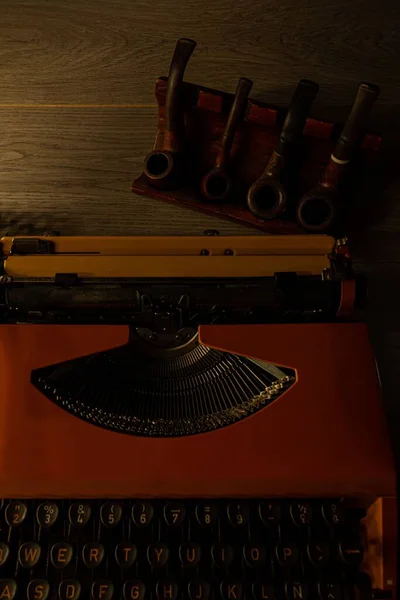 Eine Vertikale Aufnahme Einer Antiken Schreibmaschine Neben Einem Satz Tabakpfeifen — Stockfoto
