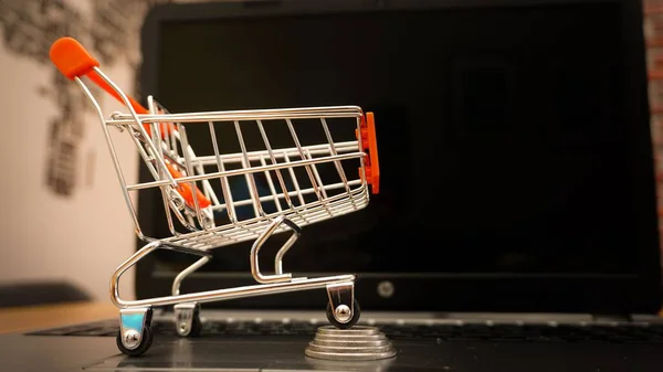 Ein Miniatur Einkaufswagen Und Eine Münze Auf Einem Laptop — Stockfoto