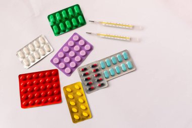 Çeşitli tıbbi ekipmanlar, termometre, ampuller, boru, uyuşturucu, tabletler, kapsüller, sprey, yama, şırınga, beyaz arka planda şişeler. İlaç.,