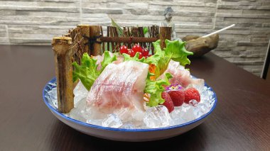 Japon restoranında servis edilen meyveli somon tabağının yakın çekimi.