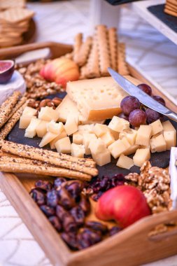 Aperatif olarak üzüm, ceviz ve dilimlenmiş peynirin dikey yakın çekimi.