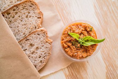 Tahtada servis edilen domates soslu ekmek manzarası.