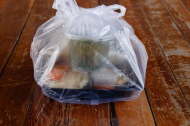 Tek kullanımlık plastik kirliliğinin sosyal sorununu gösteren plastik bir torbaya doldurulmuş yiyecek.