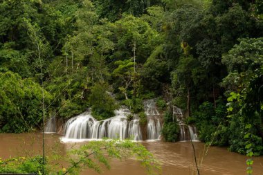 Tayland 'da yemyeşil bir ormanda Saiyok Yai şelalesinin manzarası.