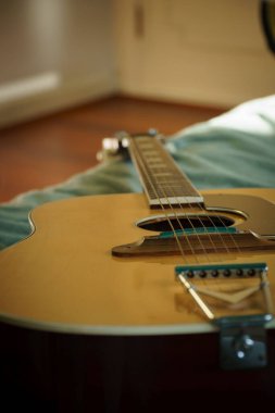 Yataktaki gitarın dikey görüntüsü.