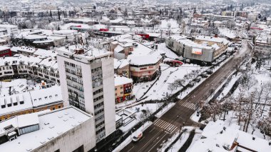 Karla kaplı bir şehrin insansız hava aracı görüntüsü.