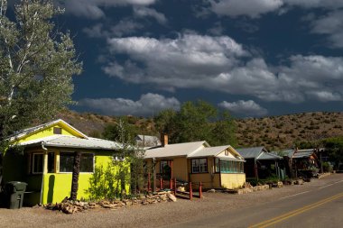 New Mexico 'da dramatik bir gökyüzüne karşı otoyolun yakınındaki küçük renkli evlerin güzel bir manzarası.