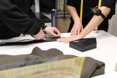 Bir elbise dikmek için ölçü alan genç tasarımcıların yakın plan fotoğrafı.