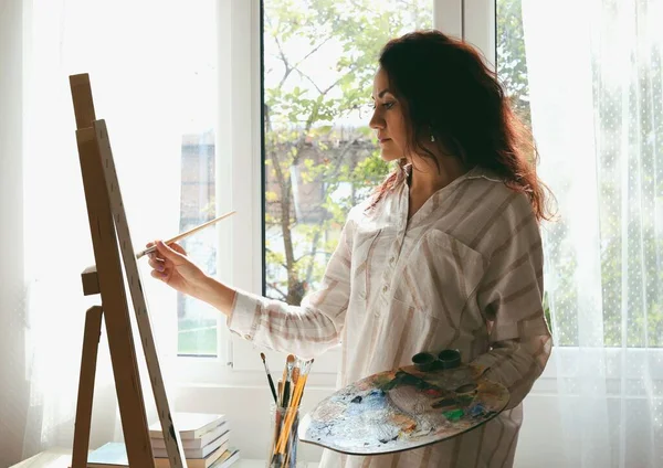 Biała Kobieta Maluje Coś Sztaludze — Zdjęcie stockowe
