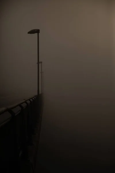 Eine Vertikale Aufnahme Der Brücke Mit Lampen Einem Nebligen Tag — Stockfoto