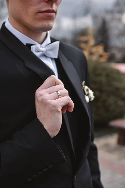 Tiro Vertical Noivo Segurando Seu Terno Preto Com Arco Casamento — Fotografia de Stock
