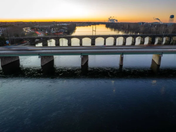 ニュージャージー州の背景にある日の出とトレントン市の川にかかる橋のドローンショット — ストック写真