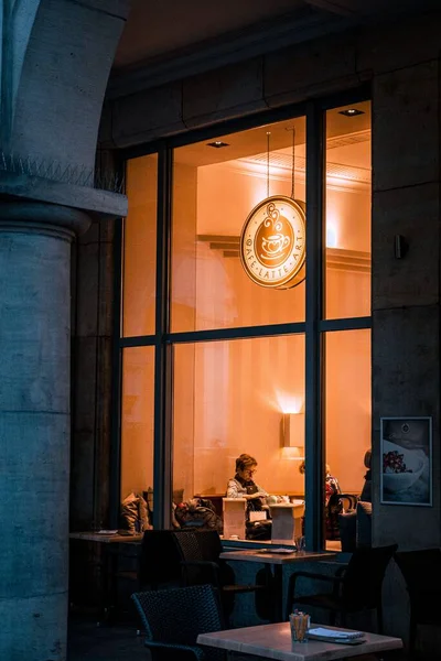 夕方のカフェに座っている人の垂直ショット — ストック写真