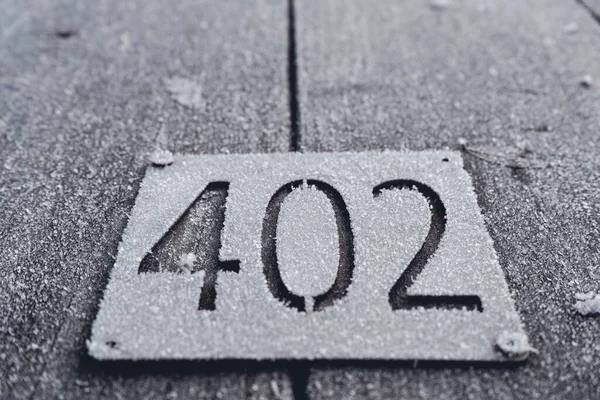 Ein Verschneites Schild Mit Der Nummer 402 Darauf — Stockfoto