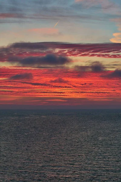 Eine Vertikale Aufnahme Eines Wunderschönen Feurigen Sonnenuntergangs Über Dem Ruhigen — Stockfoto